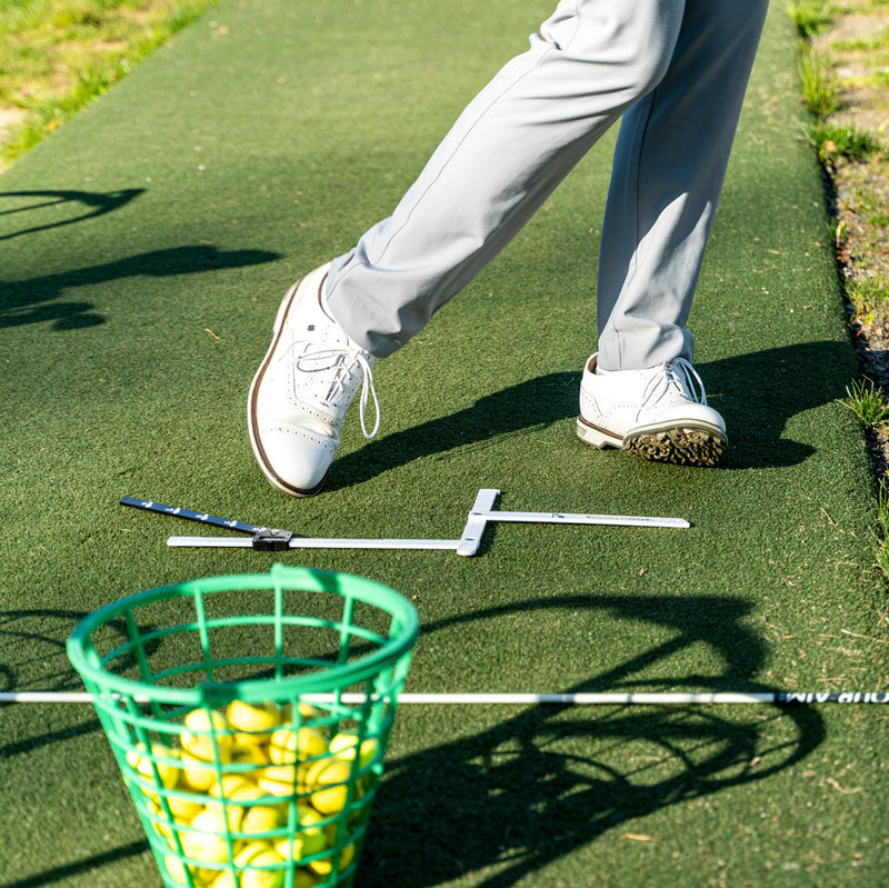 golfer using stance caddy at range with ball bucket shown after hitting ball