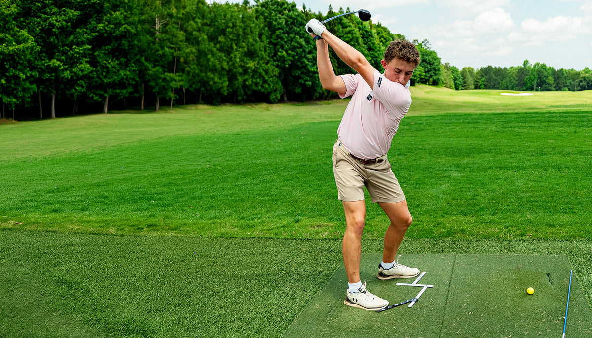Golfer using Stance Caddy golf stance and alignment training aid on the driving range